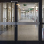 Desolate marble floored corridor at former airport Berlin Tempelhof with large glass doorways for background in urban public commerce