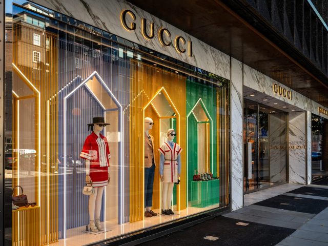 London, UK: Gucci store on Sloane Street in Knightsbridge, London. Colorful window display with mannequins displaying luxury fashion items.